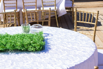 empty table with white tablecloth and green flower vase in patio restaurant place outdoor exterior decoration prepared  for birthday event