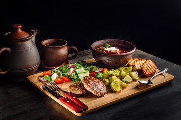 Lunch with fried meatballs, soup with meat and potatoes on a rustic-2.