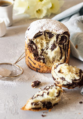 Modern pastries vanilla and chocolate cruffin whole and slice like croissant and muffin with powder sugar served with a cup of coffee.