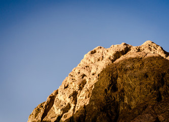 high rocky mountain against a clear blue sky
