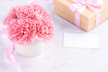 Copy space, close up, mock up, clipping path. Mothers day wording concept design. Beautiful fresh blooming baby pink color carnations isolated on bright marble background.