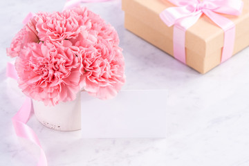 Copy space, close up, mock up, clipping path. Mothers day wording concept design. Beautiful fresh blooming baby pink color carnations isolated on bright marble background.