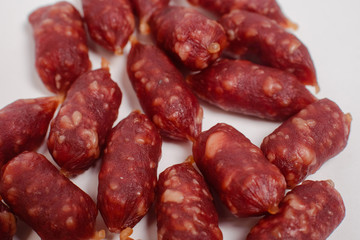 Snack to beer. Small sausages to frothy drink. Background of sausages on a light background close up.