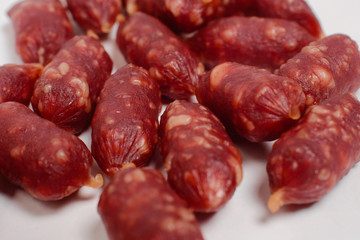 Snack to beer. Small sausages to frothy drink. Background of sausages on a light background close up.