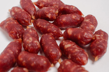 Snack to beer. Small sausages to frothy drink. Background of sausages on a light background close up.