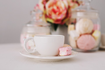 White cup with marshmallows on white background. Romantic breakfast. Concept of holiday, birthday, Easter. flat lay