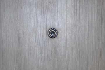 Peephole on wooden door.