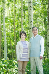 Fototapeta premium 森林の中で微笑むシニア夫婦