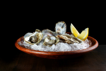 Fresh open oysters and lemon laid out on ice-2.