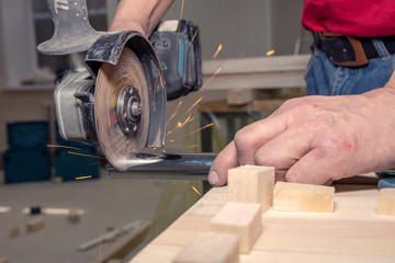 closeup man works with handheld battery circular saw cut metal