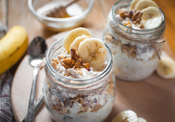 Close-up of homemade banana oats in a glass jar on wooden background