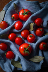 Blue cloth texture and cherry tomatoes with bay leaf. 