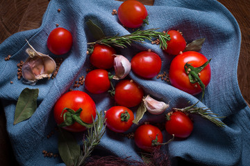 Blue cloth texture and cherry tomatoes with bay leaf. 