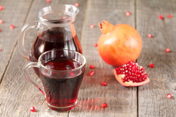 A mug of pomegranate juice on a grey wooden background.
