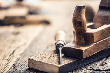 Old planer and other vintage carpenter tools in a carpentry workshop