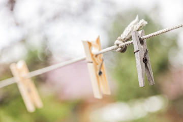 Old wooden clothespins, laundry hook, colorful, pegs, rope ,outside, sun summer decorations, village. Close-up view with Selective focus with blurred background and bokeh effect.