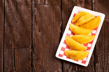 Delicious empanadas - Colombian cuisine. Wood background