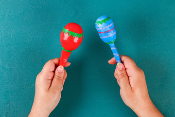Diy cinco de mayo maracas from eggs, spoons and cereals on a green background.