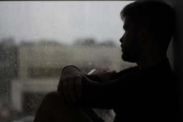 Silhouette Of A Man Sitting In The Window With Rain In Mood Of Sadness And Depression Wall Mural Fernando