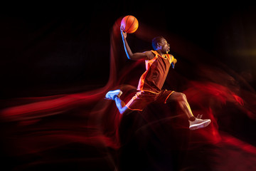 One jump before the winning. African-american young basketball player of red team in action and...
