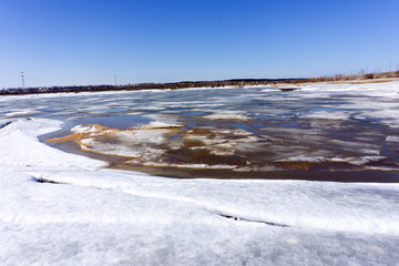 Frozen Lake Baikal in Siberia, beautiful mountains and ice, icicles, ice hummocks and cracks. Sunny winter landscape.