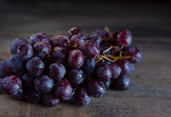 bunch of grapes lies on a wooden table
