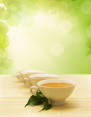 cups of tea and a green twig on the mat