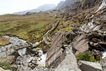 Wooden bridge on the Cwmorthin Waterfall trail in the mountains of Snowdonia National Park, Wales.