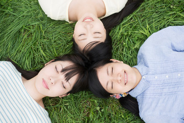 草原に寝転ぶ3人の女性