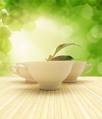 three cups of tea and green leaves
