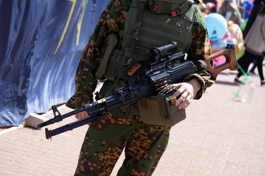 Girl styled as a soldier aims with her AK74 .