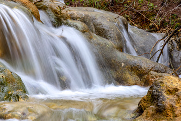 Small cascades of waterfalls on a mountain stream in the spring. Parod River. Israel
