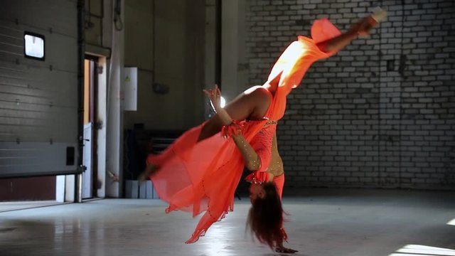 Young beautiful woman ballerina dancing in the pointe shoes and performing tricks. Performing a front flip