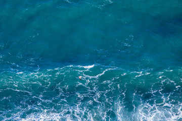Fototapeta na wymiar Blue sea texture with waves and foam