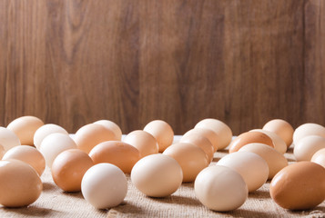 Closeup of raw eggs on the sackcloth against wooden background.Farm concept