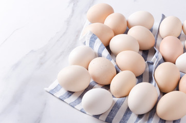 Fresh eggs on the napkin on the kitchen table.Empty space for text.Lot of eggs prepared for cooking