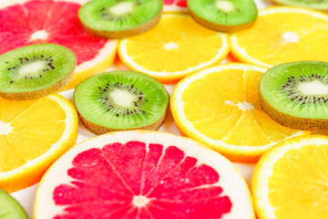 close up of citrus slice, kiwi, oranges and grapefruits isolated on white background. Fruits backdrop, selective focus