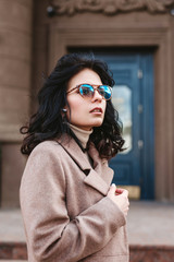 Elegant business woman wearing sunglasses and coat in the city