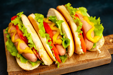 delicious hot dogs on a cutting board against a background of stone