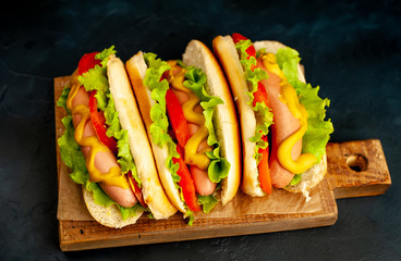 delicious hot dogs on a cutting board against a background of stone