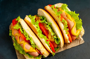 delicious hot dogs on a cutting board against a background of stone