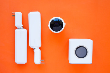 Wifi business concept. Wifi router, access points, mobile phone, laptop, camera and other wireless endpoints on the orange background. Closeup. Space for a text.