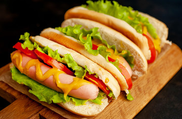 delicious hot dogs on a cutting board against a background of stone