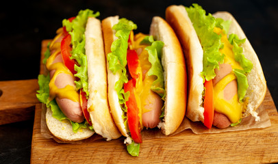 delicious hot dogs on a cutting board against a background of stone