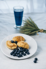 healthy light breakfast. Blue tea from orchids, blueberries, croissants on a plate with spikelets of wheat. Ingredients for yogurt. proper nutrition for a slim figure. raw food vegetarianism. diet