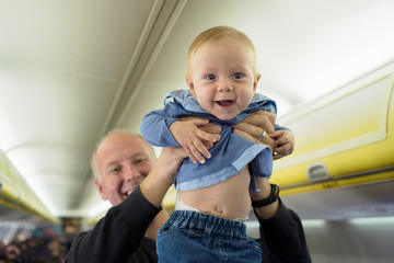 Father with his six months old baby boy in the airplane