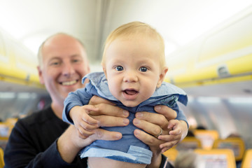Father with his six months old baby boy in the airplane