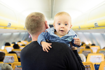 Father with his six months old baby boy in the airplane