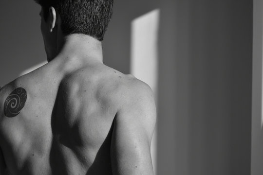 Black and White self-portrait showing the back of the model and a Maori tattoo 