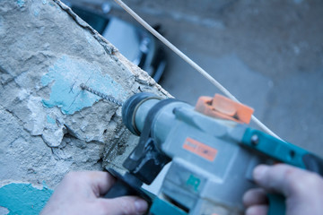 Repair and construction working indoors. Grunge background rubble and stones. Man's hands in gloves...